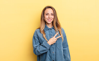 pretty caucasian woman feeling happy, positive and successful, with hand making v shape over chest,...