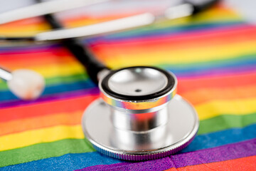 Red stethoscope on rainbow flag background, symbol of LGBT pride month  celebrate annual in June social, symbol of gay, lesbian, bisexual, transgender, human rights and peace.