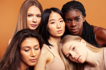 Obraz premium young pretty asian, caucasian, african woman posing cheerful together on brown background, lifestyle diverse nationality people concept