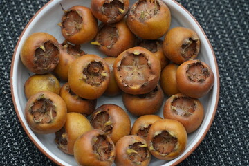 Edible and healthy  medlar fruit (mespilus germanica, family rosaceae) harvested in December. Medlar fruits are available in winter and are eaten when baked or cooked as a jam. Garbsen, Germany