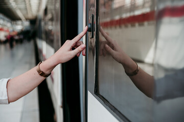 Young woman pressing button on train at railroad station