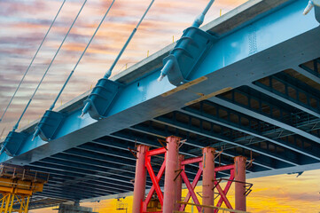 Fragment of a new cable-stayed road bridge at sunset. Desktop background picture. Road traffic,...