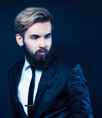 portrait of young bearded hipster guy on gray dark background close up, brutal modern man in suit, lifestyle people concept