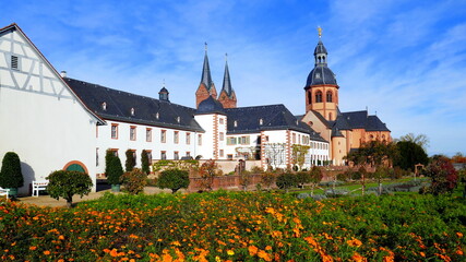 malerische Basilika und Kloster in Seligenstadt mit  Klostergarten und Blumen unter blauem Himmel