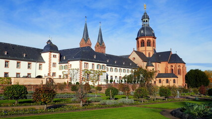 Fototapeta na wymiar malerische Basilika und Kloster in Seligenstadt am Main mit gepflegtem Klostergarten unter blauem Himmel
