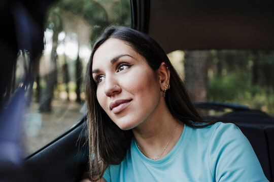 Beautiful young woman contemplating while sitting in car