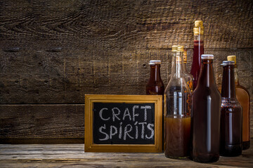 Craft spirit alcohol. Various bottles and glass with hand crafted hard strong alcohol drinks. Old...