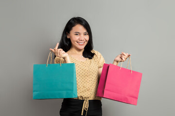 Fototapeta na wymiar Beautiful asian woman smiling while holding shopping bags