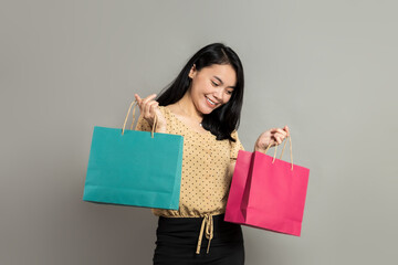 Fototapeta premium Beautiful young woman smiling while holding shopping bags