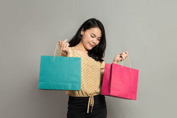 Beautiful young woman smiling while holding shopping bags