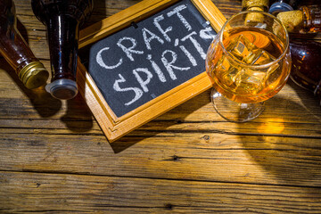 Craft spirit alcohol. Various bottles and glass with hand crafted hard strong alcohol drinks. Old...