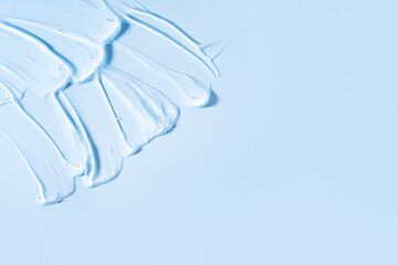 Obraz na płótnie Canvas Transparent serum is smeared in the corner of the blue background
