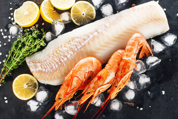 Cod shrimp background. White fish fillet, frozen shrimps on a dark background with lemon, ice,...