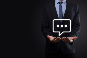 Businessman holding a message icon, bubble talk notification sign in his hands. Chat icon, sms icon, comments icon, speech bubbles