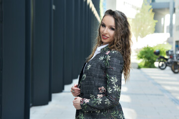 Fototapeta premium Businesswoman in Poland. Portrait of young office lady with modern building as background.
