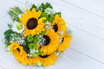 Wedding bouquet of sunflower on a wooden background. Top view with copy space.