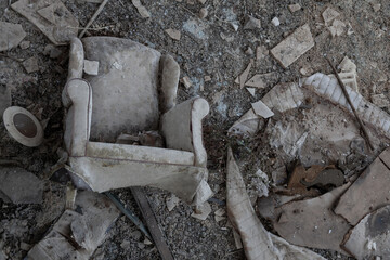 Flatlay overlooking an overturned chair on the floor in a room with scattered rubbish and broken...
