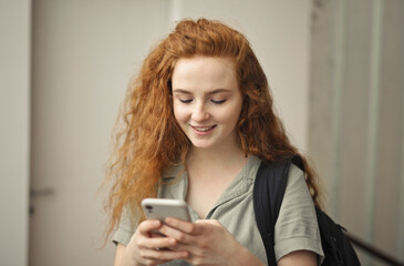 Fototapeta premium young woman in school uses smartphone