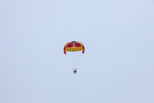 Tourists fly over the sea and the beach on a parachute. Sport and recreation for tourists in turkey