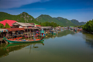 Fototapeta na wymiar Fishing village in Thailand,Fishing boats float in the water at the fishing village harbor at Ban Bangpu , Khao Sam Roi Yot National Park