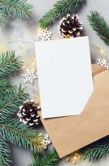 Christmas greeting card mockup with envelope and fir tree with cones and garlands