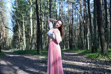 Fototapeta premium Pretty, young woman posing in the forest. Green surroundings during spring in Poland.
