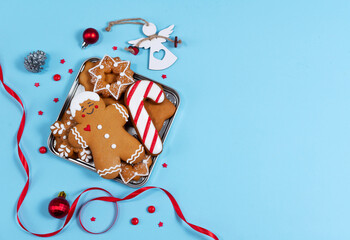 Christmas cookies on square plate on on blue background. Greeting card. Christmas present. Gratitude and love concept. Traditional christmas treating