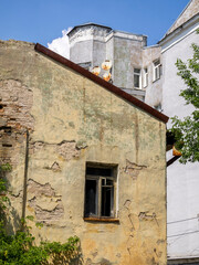 An old abandoned ruined building in the center of the city. Broken window without glass.