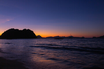 Fototapeta premium Silhouette of island on sunset on Philippines island, El Nido. Scenic evening landscape on sunset. Tropical coast in night dusk. Amazing twilight at seaside.Tropical tourism. Dramatic moody sky.