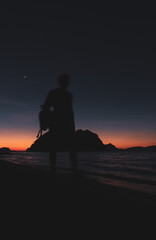 Fototapeta premium Silhouette of people watching sunset on Philippines island, El Nido. Scenic evening landscape on sunset. Tropical coast in night dusk. Amazing twilight at seaside.Tropical tourism. Evening mood.
