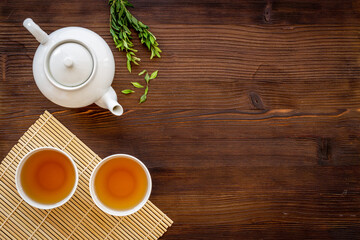 Fototapeta na wymiar Tea drinking with white teapot and black tea in two cups