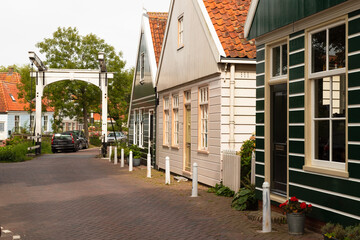 Narrow street with traditional painted wooden houses in the picturesque village of Ransdorp.