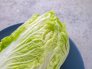 Top view of a piece of Chinese cabbage on a blue plate. Beautiful green leaves.