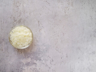 Top view of chopped onion in a transparent bowl. Copy space.