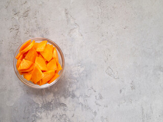 Transparent bowl with chopped carrots. Paysanne cut. Copy space.