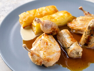 Side view of potato gratin and quail with two sauces.