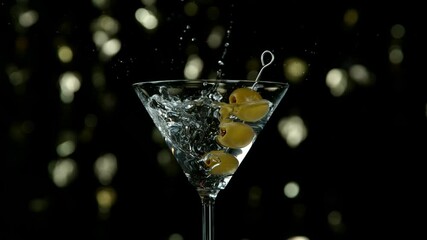 Super slow motion of falling olives into martini drink with camera motion. Filmed on high speed cinema camera at 1000 fps. - Powered by Adobe