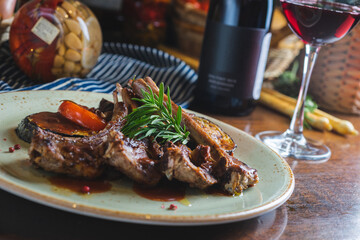 Fried ribs with a glass of red wine on a table in a restaurant close-up