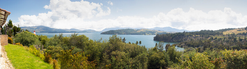 Fototapeta na wymiar Beautiful Colombian Tota lake panoramic photography with forest and andean mountains at background in sunny midday