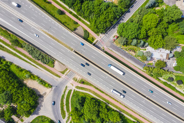 Traffic trails on highway intersection. Aerial View. Green Fores