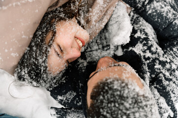 Loving couple in puffer jacket on a winter walk. Man and woman having fun in the frosty forest....