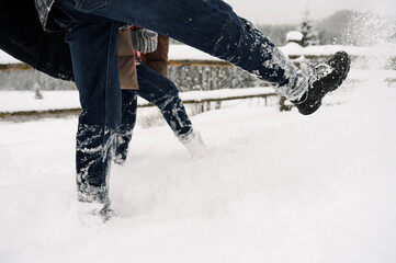 Loving couple in puffer jacket on a winter walk. Mans and womans legs. Romantic date in winter time.Christmas mood of a young family.Winter lovestory