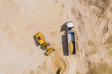 Aerial view of sand quarry with trucks and bulldozers. Heavy bul