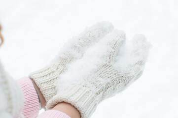 snow on palms girls, close-up of white knitted mittens, rest, winter fun