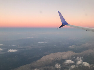 flying and traveling, view from airplane window on the wing on sunset time