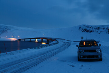 Fototapeta na wymiar man inside a car with road and snowy bridge at night