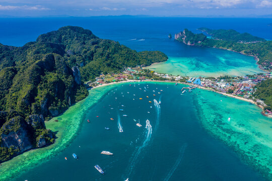 Blue clear water with boats. Green tropical island Phi Phi, palm