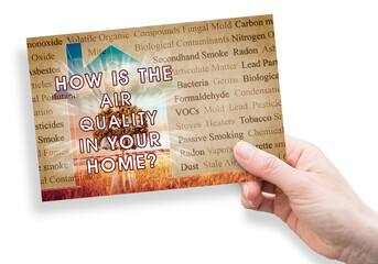 Fototapeta premium HOW IS THE AIR QUALITY IN YOUR HOME? - concept with the most common dangerous domestic pollutants in our homes and hand holding a postcard