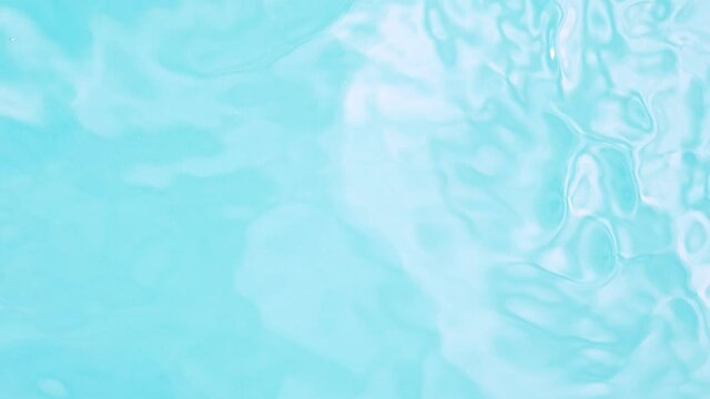 Super slow motion of water surface on light blue background. Filmed on high speed cinema camera, 1000 fps.