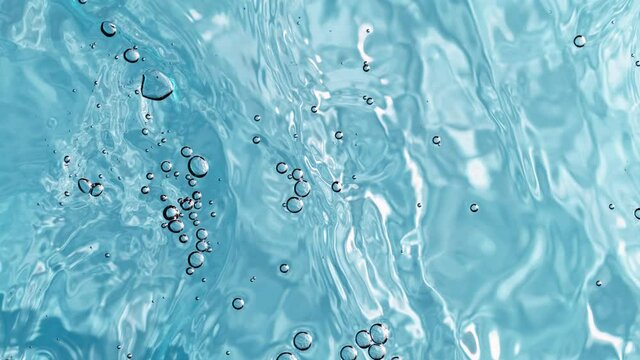 Super slow motion of water surface on light blue background. Filmed on high speed cinema camera, 1000 fps.